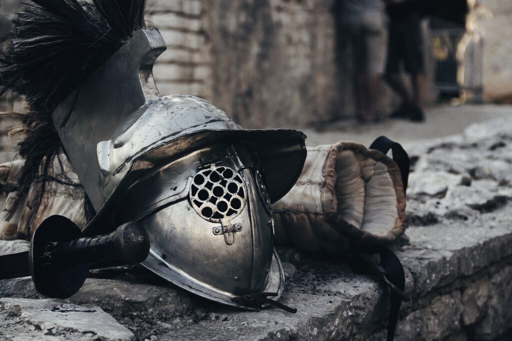 metal gladiator helmet sitting on stone wall to represent historic dystopian writing prompts